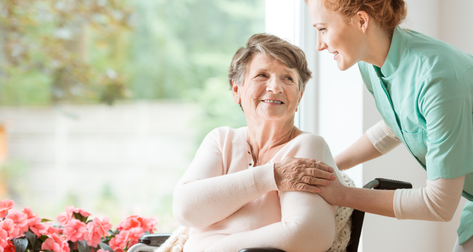 Young nurse helping an elderly woman in a wheelchair. Nursing home concept
